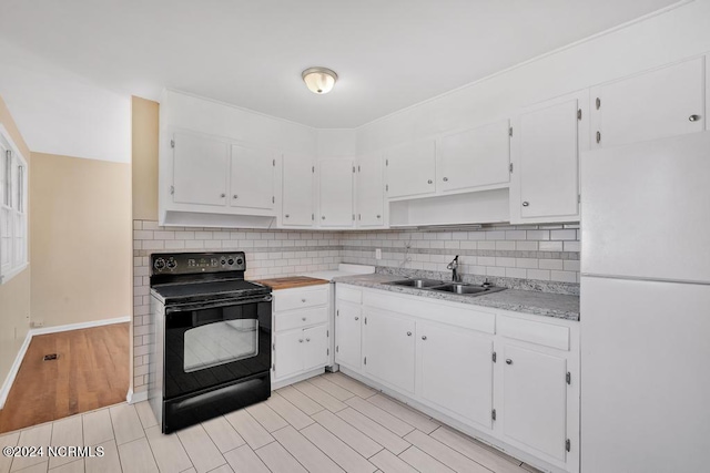 kitchen with decorative backsplash, sink, electric range, white refrigerator, and white cabinetry