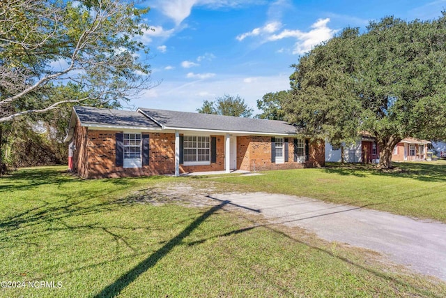 single story home featuring driveway, brick siding, and a front yard