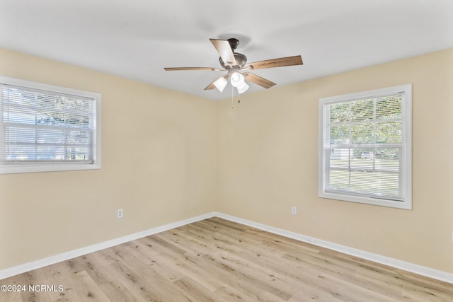 empty room with ceiling fan and light hardwood / wood-style flooring