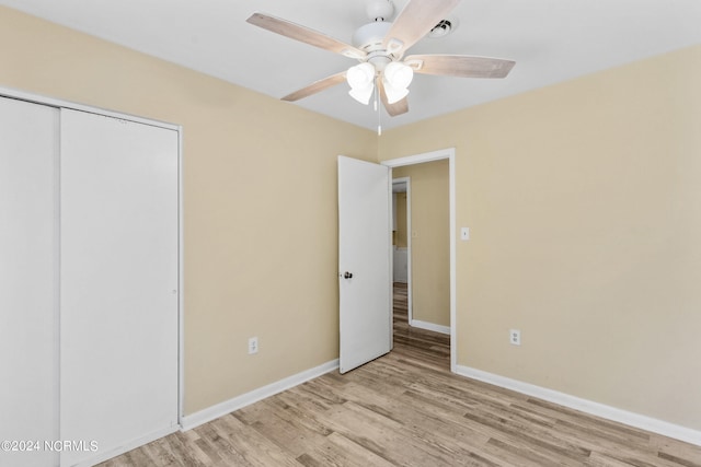 unfurnished bedroom featuring a closet, light wood-type flooring, and ceiling fan