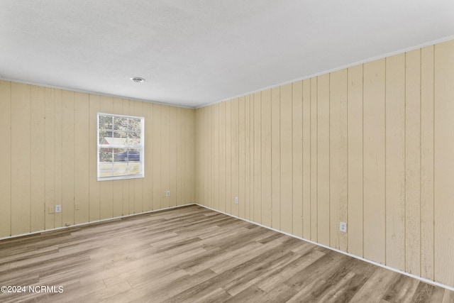 unfurnished room with wood walls and hardwood / wood-style floors