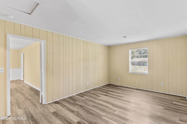 unfurnished room featuring wood walls and hardwood / wood-style floors