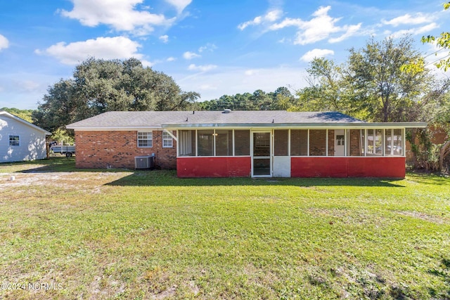 back of house with a sunroom, a lawn, and central AC unit