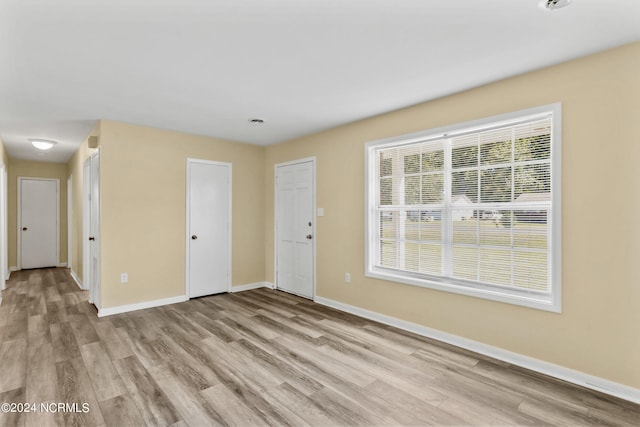 unfurnished room with light wood-type flooring