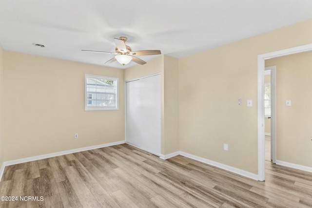 unfurnished bedroom with light wood-type flooring, a closet, and ceiling fan