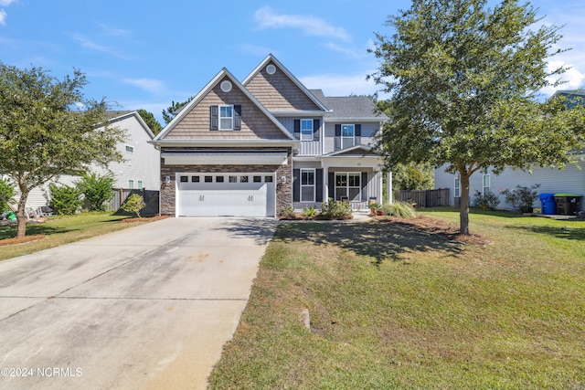 craftsman-style house featuring a garage, covered porch, and a front yard