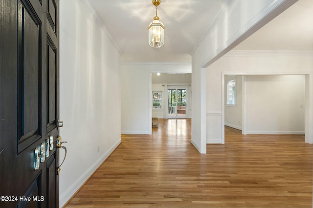 entryway with a chandelier, hardwood / wood-style flooring, and ornamental molding