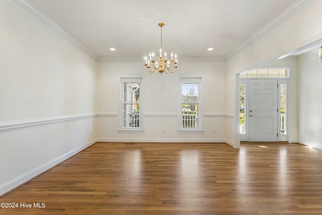 entrance foyer featuring dark wood-type flooring, crown molding, and a notable chandelier