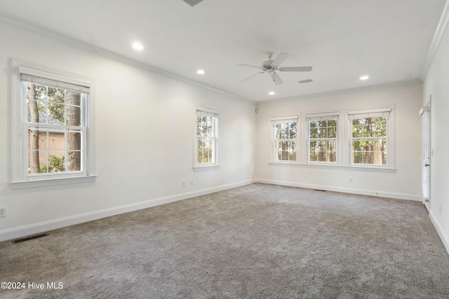 carpeted spare room featuring ceiling fan, crown molding, and a wealth of natural light