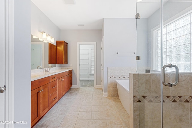 bathroom featuring plus walk in shower, tile patterned flooring, and vanity