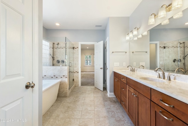 bathroom featuring plus walk in shower, vanity, and tile patterned flooring