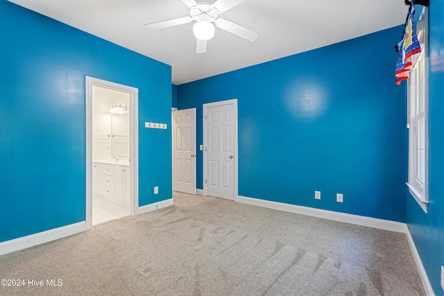 unfurnished bedroom with carpet, connected bathroom, and ceiling fan