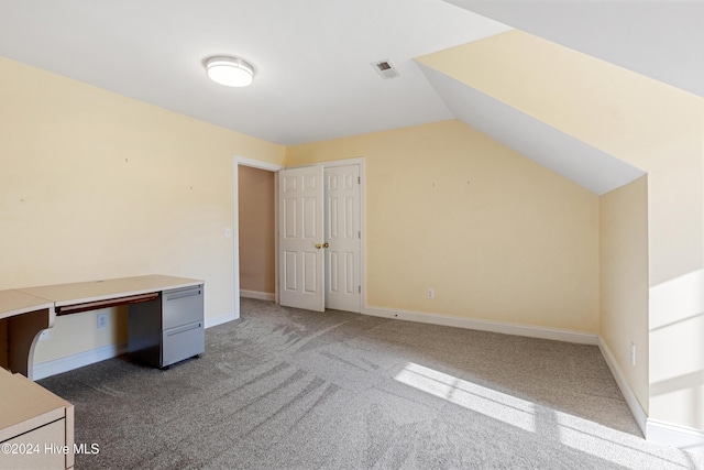 unfurnished office featuring carpet floors and vaulted ceiling