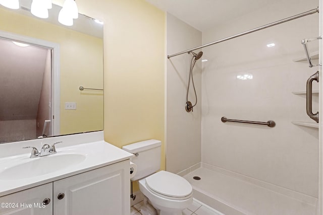 bathroom with tile patterned floors, vanity, toilet, and walk in shower