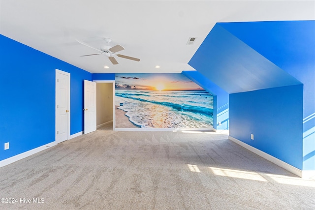 interior space featuring ceiling fan, carpet floors, and vaulted ceiling