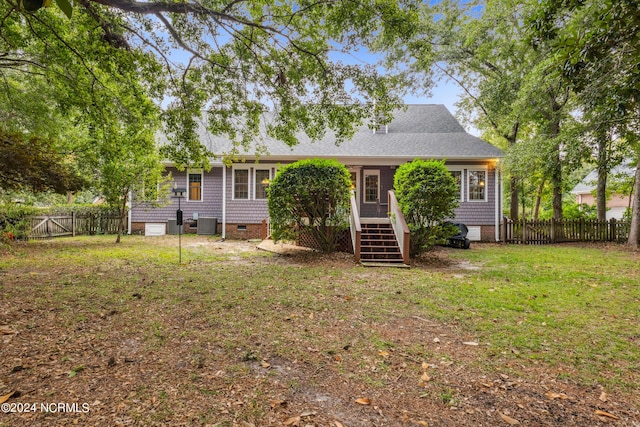 view of front of property featuring cooling unit and a front lawn