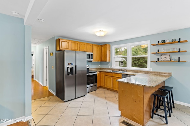 146 NE 5th St, Oak Island, NC 28465 - kitchen with light tile patterned floors, brown cabinetry, a sink, and dishwasher