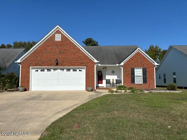 view of front of property featuring a garage and a front lawn