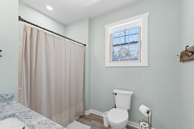 bathroom featuring walk in shower, hardwood / wood-style flooring, and toilet