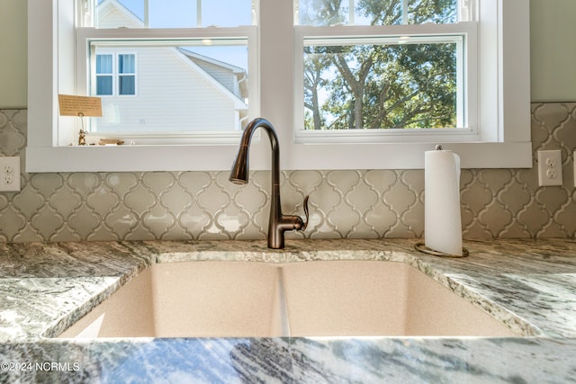 room details featuring light stone countertops and sink