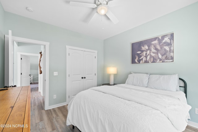 bedroom with ceiling fan, a closet, and light hardwood / wood-style floors