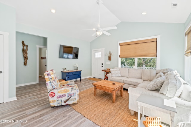 living room featuring ceiling fan, light wood-type flooring, and vaulted ceiling