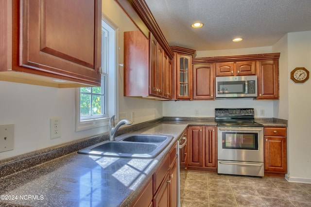 kitchen featuring appliances with stainless steel finishes, a textured ceiling, and sink