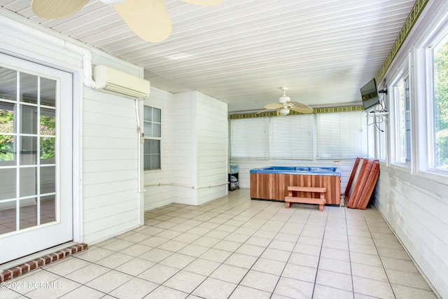 unfurnished sunroom featuring an AC wall unit, ceiling fan, and a jacuzzi