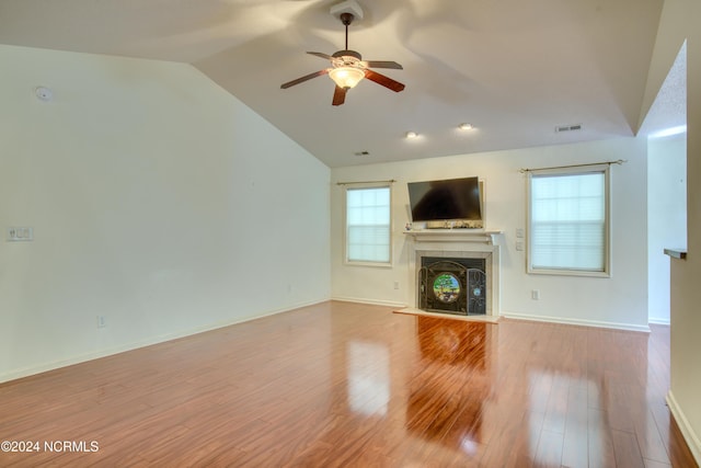 unfurnished living room featuring ceiling fan, light wood-type flooring, and vaulted ceiling