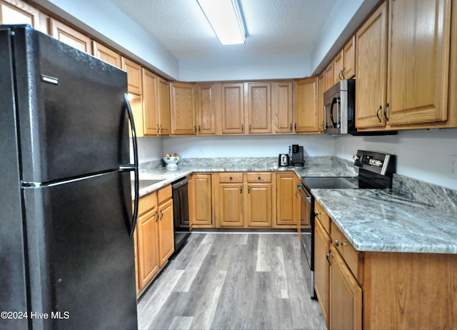 4746 Rail Ct SW, Shallotte, NC 28470 - kitchen with black appliances, light wood finished floors, and light stone counters