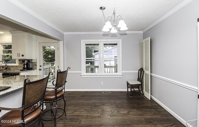 dining space featuring a textured ceiling, an inviting chandelier, dark hardwood / wood-style flooring, and crown molding