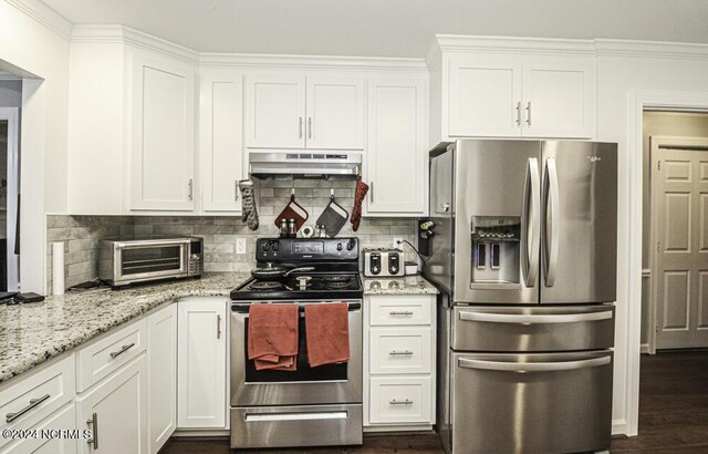 kitchen featuring white cabinetry, appliances with stainless steel finishes, decorative backsplash, light stone countertops, and crown molding