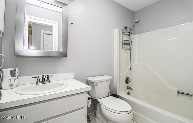 full bathroom featuring shower / bathing tub combination, vanity, toilet, and a textured ceiling