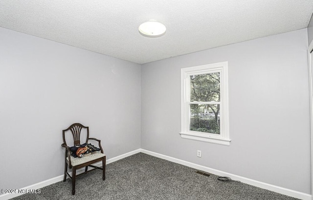 spare room with dark carpet and a textured ceiling