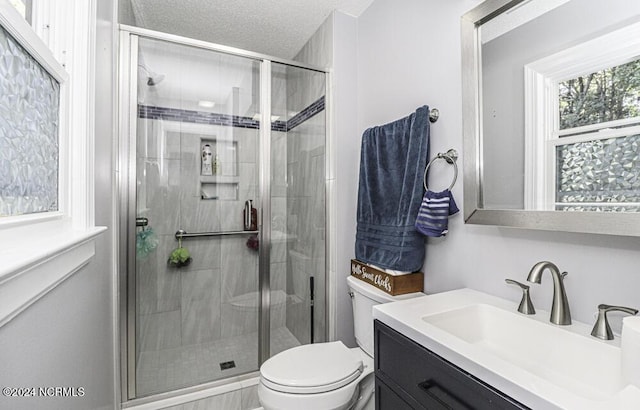 bathroom with a textured ceiling, toilet, an enclosed shower, and vanity