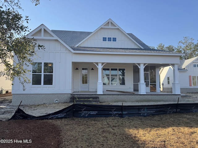 view of front of property with board and batten siding, covered porch, and a shingled roof