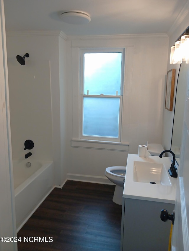 full bathroom with hardwood / wood-style flooring, toilet, ornamental molding, vanity, and washtub / shower combination