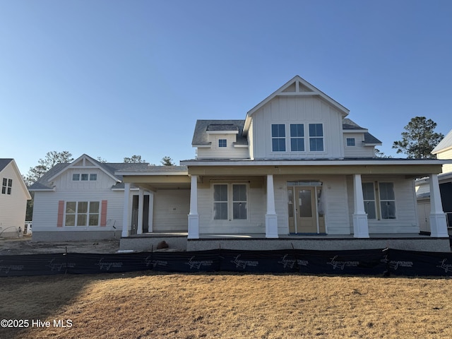 view of front of house featuring a front lawn, a porch, and board and batten siding