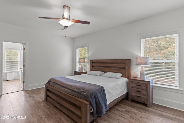 bedroom with wood-type flooring and multiple windows