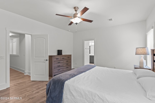 bedroom with light hardwood / wood-style flooring, ensuite bath, and ceiling fan