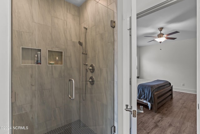 bathroom with ceiling fan, hardwood / wood-style flooring, and an enclosed shower