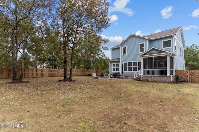 rear view of property with a lawn and a sunroom