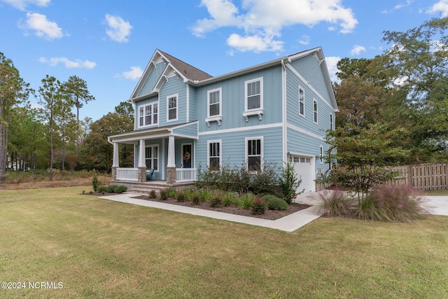 view of front of house with covered porch, a front lawn, and a garage