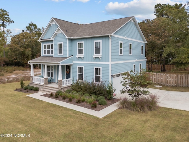 view of front of property with a porch, a front yard, and a garage