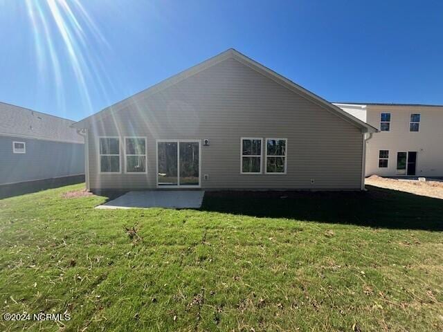 back of property featuring a yard and a patio