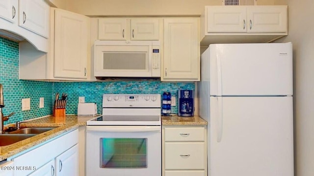 kitchen featuring white appliances, tasteful backsplash, and white cabinetry