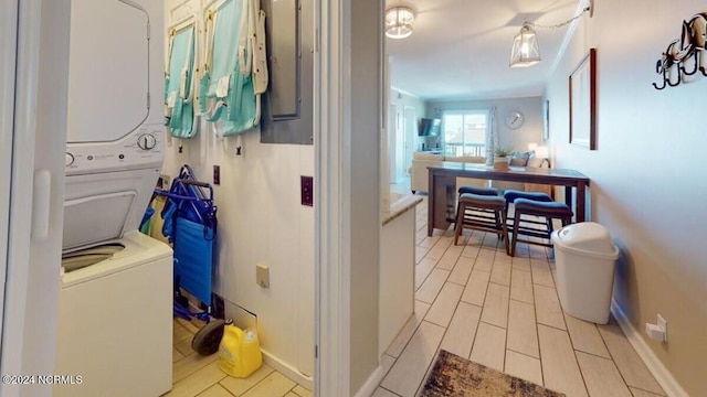 clothes washing area featuring stacked washer / drying machine