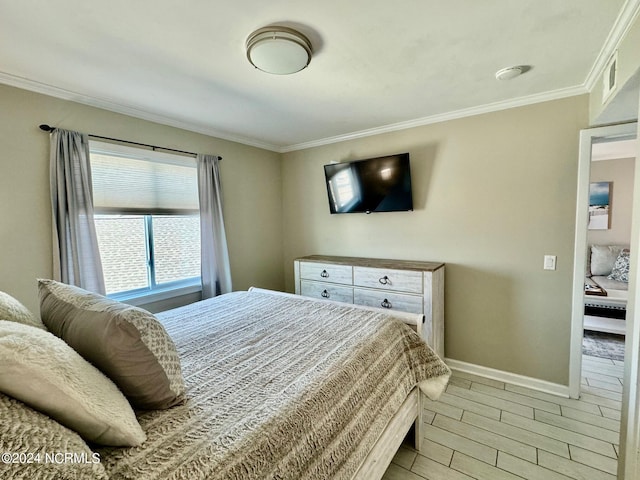 bedroom featuring light wood-type flooring and crown molding