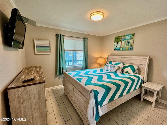 bedroom with wood-type flooring and ornamental molding