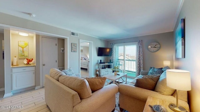 living room with light wood-type flooring and crown molding